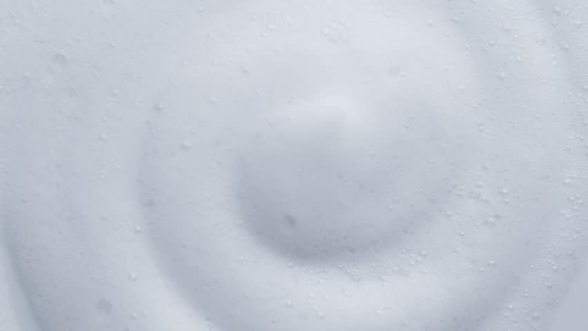 Foam background. Liquid soap bubbles, Froth bubbles backdrop. Soap foam popping bubble rotating, white backdrop. Soap sud macro structure close-up. Clean, cleaning, washing, laundry. 