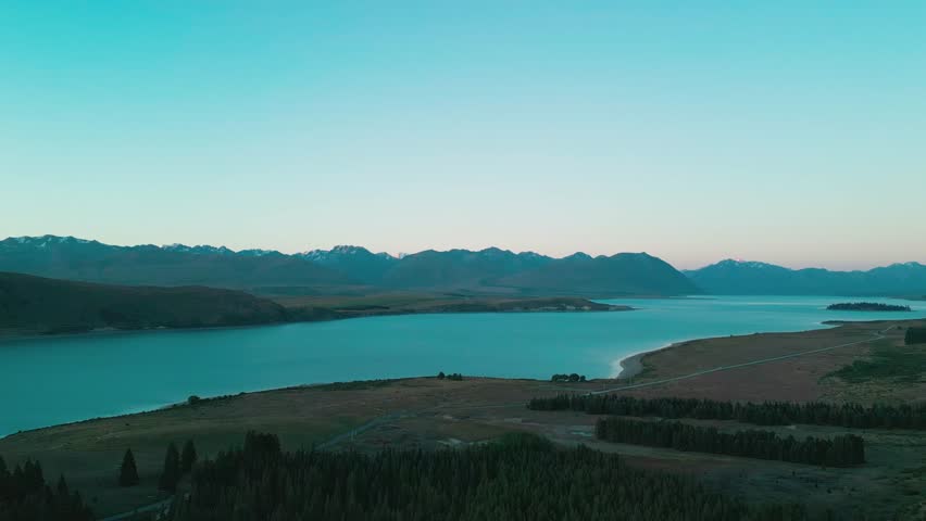 Drone aerial of Lake Tekapo both sides of lake with mountian range in background