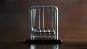 Metal Newton cradle placed on wooden background as representation of momentum concept, cradle balance steel balls, school teaching supplies, desk toy, gifts home decoration - Powered by Shutterstock - Get 15% off with code: PIKWIZARD15