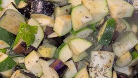 The top down view of ichiban eggplant and zucchini being cooked in a pan.