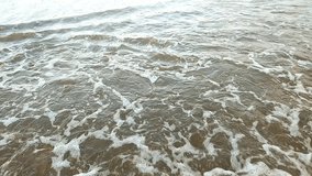 Video of thin sea waves pooling on the shoreline in the afternoon, very suitable as a background for videos, photos, etc.