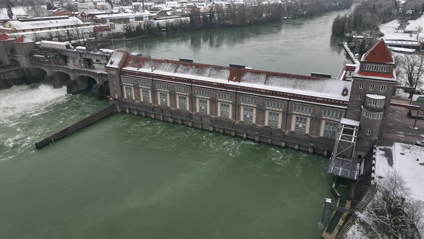 Backwards drone dolley shot of a traditional hydro power plant in winter time at the Rhine in Germany.