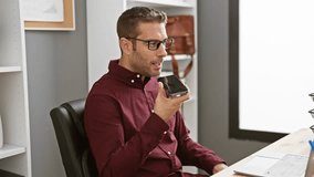Hispanic man in glasses using smartphone in modern office