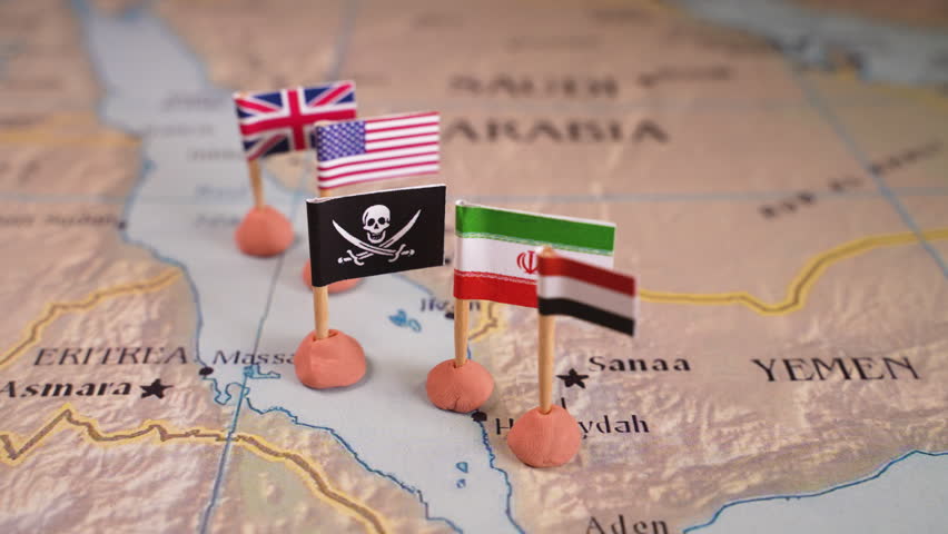 Flags of the United States and Iran and their respective allies surrounding a pirate insignia onto a map of the Red Sea region. It symbolically represents the intricate geopolitical dynamics and