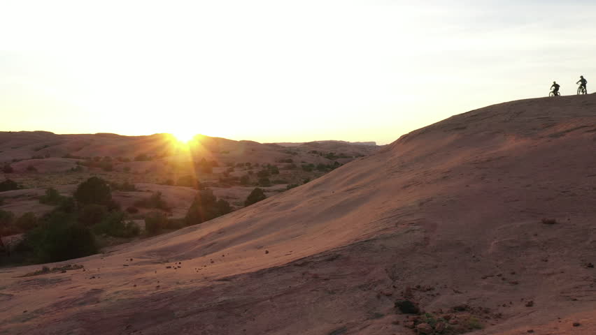 Mountain bike, people on hill and race, training or extreme sports with cardio, fitness and outdoor journey in sunset. Friends or cycling athlete on bicycle for exercise, competition and adventure