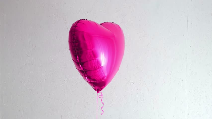 One beautiful big pink heart shaped balloon with ribbon isolated on a white background. Birthday party gift. Floating object. Inflatable ball by helium gas. Valentines day gift. Love symbol. 4k. - Powered by Shutterstock - Get 15% off with code: PIKWIZARD15