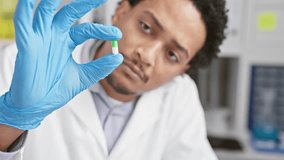 Man in lab examines capsule with precision, reflecting healthcare, science, and medical research. - Powered by Shutterstock - Get 15% off with code: PIKWIZARD15