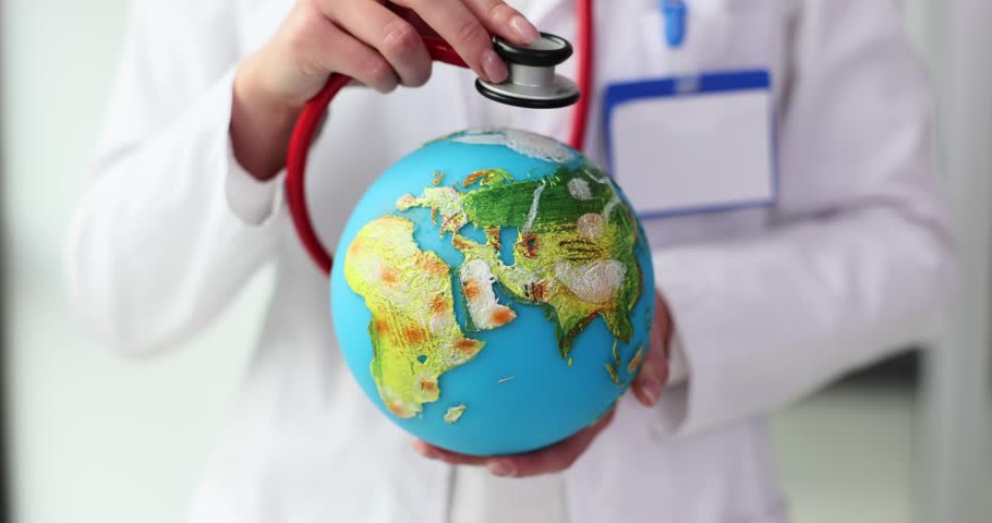 Doctor places stethoscope on Earth model. Woman listens to small Earth globe emphasizing need for planetary care and environmental health slow motion Royalty-Free Stock Footage #3414955121