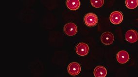 Romantic red and white candles in the shape of a heart on black background.
