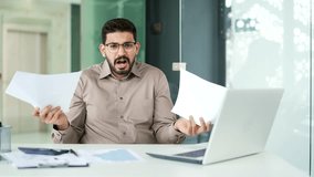 Confused businessman in glasses having difficulty with paper work sitting at workplace in business office. Puzzled entrepreneur looks at documents and cannot understand the problem looking at camera - Powered by Shutterstock - Get 15% off with code: PIKWIZARD15