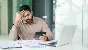 Overworked businessman in glasses has difficulty filling out documents sitting at workplace at desk in business office. Exhausted financier is tired of doing paper work. Man has despair disappointment - Powered by Shutterstock - Get 15% off with code: PIKWIZARD15