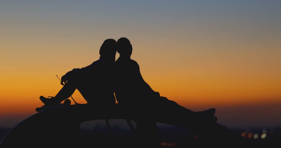 Couple stargazing together with a astronomical telescope.