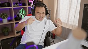 Triumphant young chinese streamer, headset worn, celebrating victorious gaming night in room, filled with technology  digital entertainment