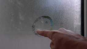 Man drawing with his finger on foggy glass sad emoticon symbol of rain and cold, Window glass with raindrops. Imitation of children's inscriptions. Concept of bad weather and rainy autumn season. - Powered by Shutterstock - Get 15% off with code: PIKWIZARD15