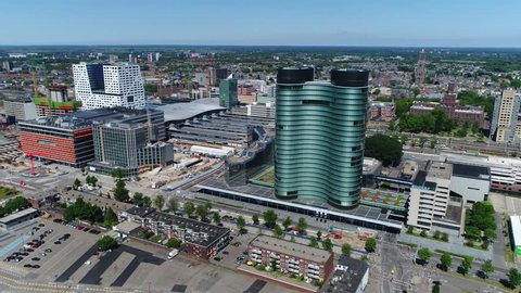 Aerial bird-eye view footage downtown Utrecht city showing the Utrecht skyline modern skyscraper and other modern buildings and on right showing the famous Dom Tower  famous tourist attraction 4k