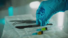 A doctor surgeon in protective gloves takes a surgical scalpel with his hand in the research room. Camera movement professional worker uses scalpel in surgery studying research data surgery - Powered by Shutterstock - Get 15% off with code: PIKWIZARD15