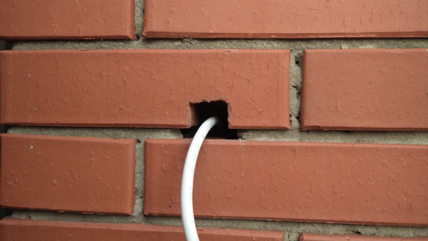 Electrical Wires are pulled out of the brick wall Royalty-Free Stock Footage #3415342551