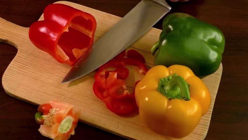 Close up shot of chef's hands using a knife cutting a fresh bell pepper on wooden board. Cooker preparing Cutting peppers on the cutting board. Chop the green pepper into small pieces with a knife
 Royalty-Free Stock Footage #3415354333