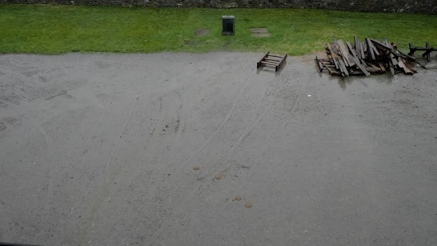 A tilt reveal of the interior of Fort Ticonderoga as gentle rain falls on the stone walls and canons.