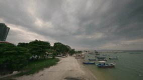 Captivating FPV aerial footage showcases the traditional boats, local architecture, and the vibrant coastal environment.