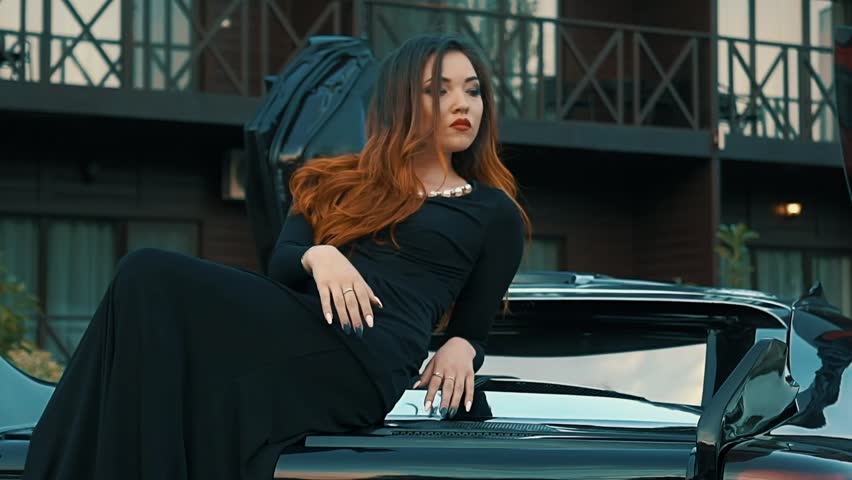 Slow Motion Model Posing Lying On The Hood Of The Car
