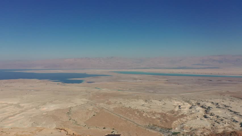 Aerial panoramic view of the Dead Sea and the ancient fortification Masada in the Southern District of Israel situated on top of an isolated rock plateau, eastern edge of the Judaean Desert, Israel