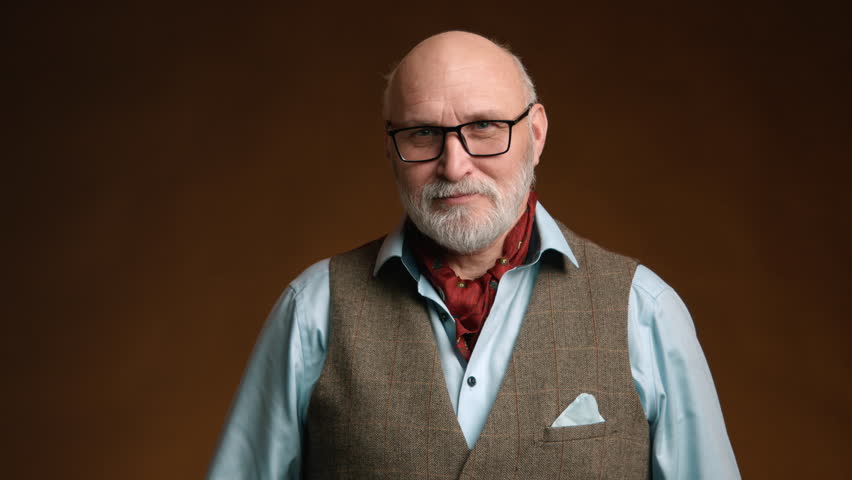Charming senior man with a white beard wearing glasses gives a thumbs-up. His attire includes a light blue shirt and a tweed waistcoat, all against a warm brown background. Camera 8K RAW. 