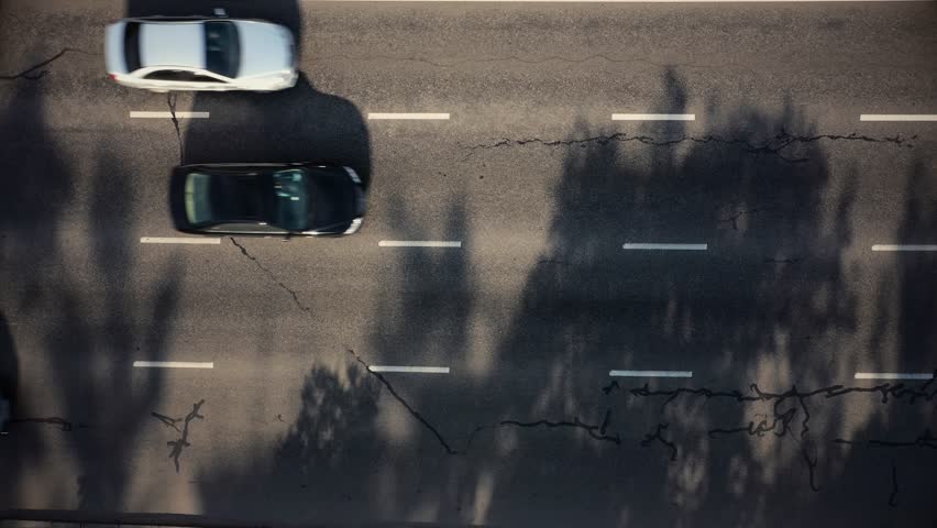 Aerial drone view of cars driving by the highway asphalt road. Cars traffic on the city street.