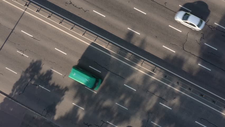 Top view of fast moving cars and trucks on highway. Urban outdoor background.