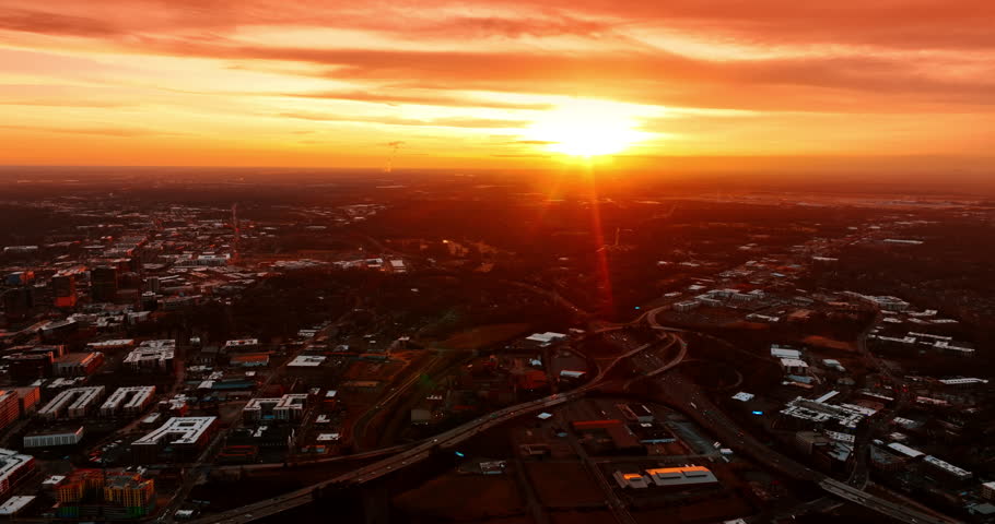 Bright sun setting above the cityscape. Aerial perspective on Charlotte, North Carolina, USA from top perspective.