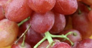 Macro video closeup of ripe, sweet and red grapes on a rotating plate