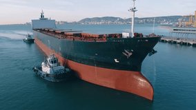 Big cargo ship enters the port against the backdrop of the city's port infrastructure. Drone Footage - Powered by Shutterstock - Get 15% off with code: PIKWIZARD15