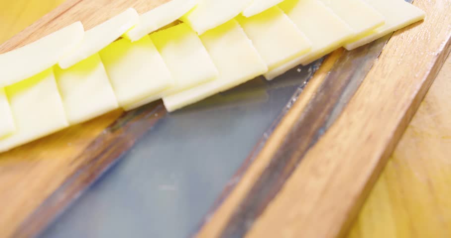 Preparation of a delicious starter of ham, cheese, red grapes, purple grapes, cherry tomato, jelly, fresh olives. Delicious board of hams and cheeses with fruit to share at a table gourmet party