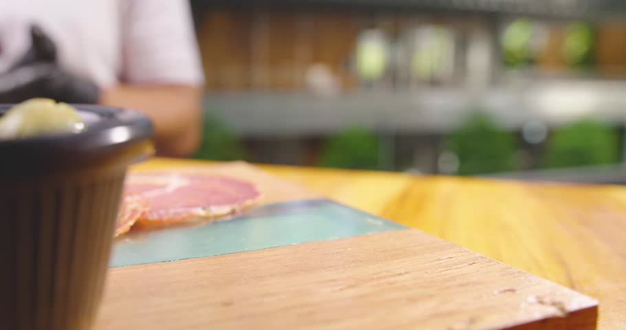 Preparation of a delicious starter of ham, cheese, red grapes, purple grapes, cherry tomato, jelly, fresh olives. Delicious board of hams and cheeses with fruit to share at a table gourmet party