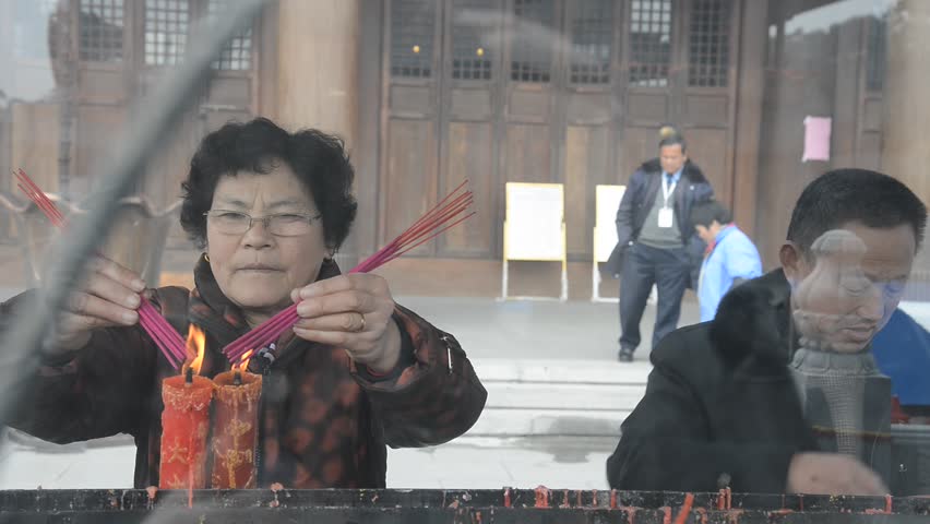 Ningbo, CHINA - Feb 13, 2013: People light candles and incense in Xuedou Temple