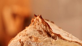 Bread crust video. 4K close up video tilt camera movement with the crust of a fresh home made bread got out the oven. Tasty sourdough bread bakery.