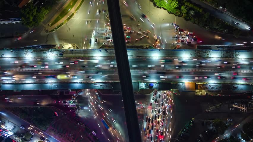 Vertical video. Aerial time-lapse of evening traffic at an intersection in Hanoi, Vietnam.