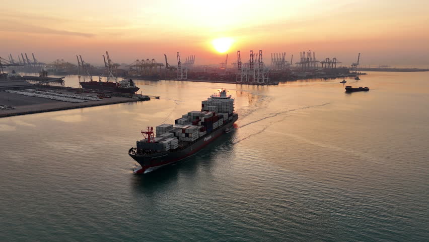 Aerial view of Cargo Container Ship at sunrise. container ship running out of cargo shipyard sea port. export shipping industry freight and transportation logistics concept. commercial shipping by sea