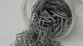 An artistic mix of scattered paper clips, forming an intriguing visual composition on a light background.