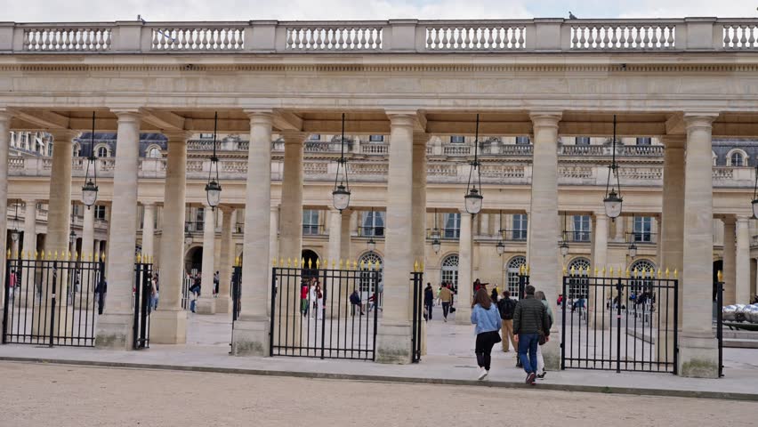 People walk near a building with columns in the historical part of Paris. 4k video.