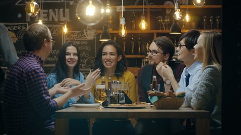 Diverse Group of Young People Have Fun in Bar, Have Conversation, Telling Stories and Jokes. They Drink Various Drinks. They're in the Stylish Hipster Restaurant. 