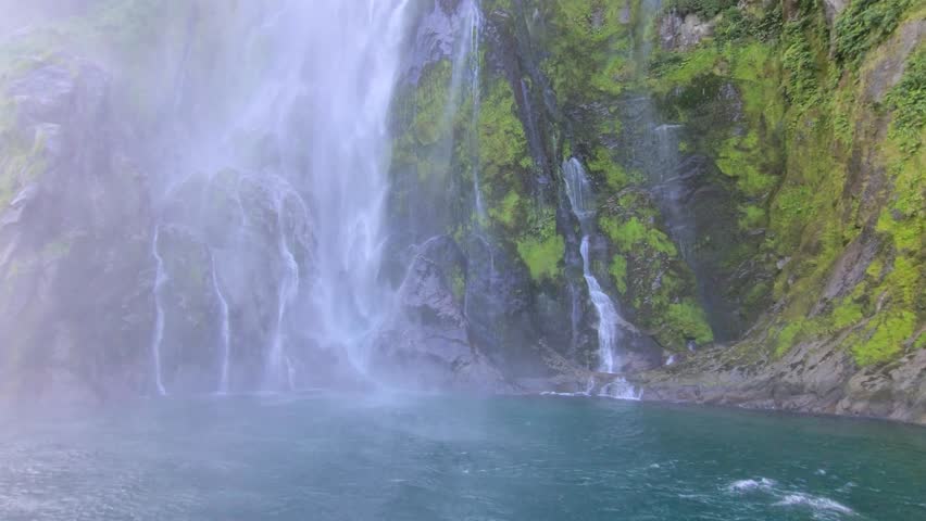 Stirling Falls (Wai Manu in Māori language) in Milford Sound (Piopiotahi) with surrounding mountains. In Fiordland National Park on the South Island of New Zealand. Royalty-Free Stock Footage #3416181027