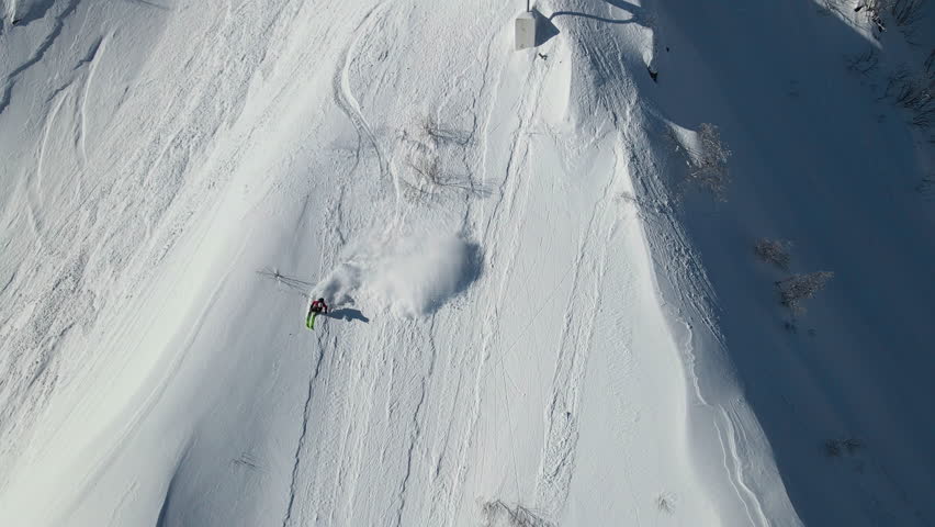 Drone view of a skier descending an unprepared slope in the mountains in winter. Off-piste skiing. Freeride
