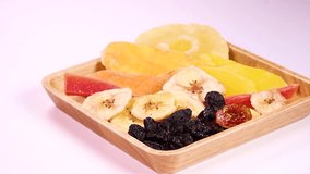 Dried fruit on a wooden plate on white background rotating - Powered by Shutterstock - Get 15% off with code: PIKWIZARD15