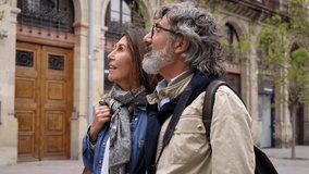 Quiet adult Caucasian couple chatting and walking together outdoor. Mature married partner watching something enjoying relaxing travel stroll along tourist street. Positive relationship, weekend trip - Powered by Shutterstock - Get 15% off with code: PIKWIZARD15