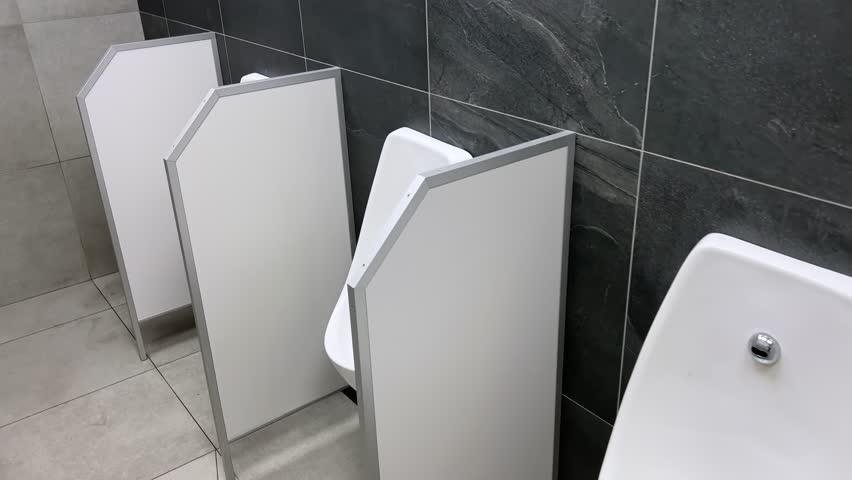 Rows of modern urinals with a sensors WC flush in a public men