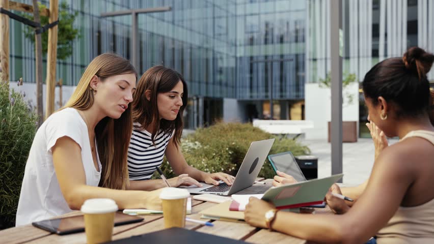 Young entrepreneur women freelancers team working on laptop the city