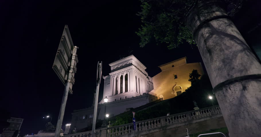 Cityscape of a night square in Rome, Italy. Historical houses with columns illuminated in the ancient capital, tourist travel and places. High quality 4k footage
