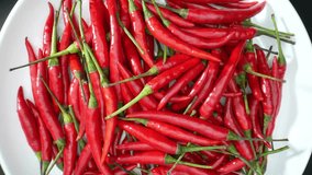 Close-up footage captures the vibrant red hue and intricate textures of chili peppers. Each wrinkle and shine conveys their fiery essence. Capsaicin concept. Food stock footage. 4K.
