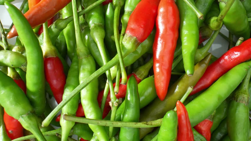 Experience the artistic allure of colorful chili peppers in macro video. Marvel at the graceful curves, rich hues, and mesmerizing patterns that make these fiery gems a feast for the eyes.
